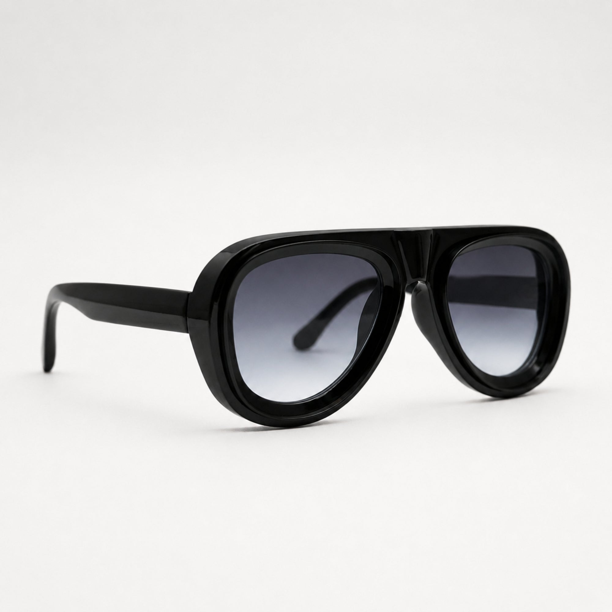 Vue de trois quarts des lunettes de soleil Black Sky noires Osour Eyewear avec monture oversize brillante et verres gris dégradés