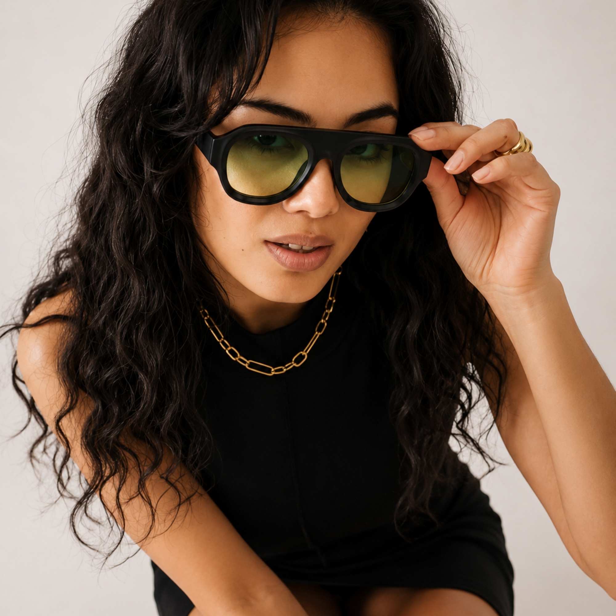 Femme portant les lunettes de soleil LA DEEEP noires Osour Eyewear avec monture oversize et verres verts dégradés