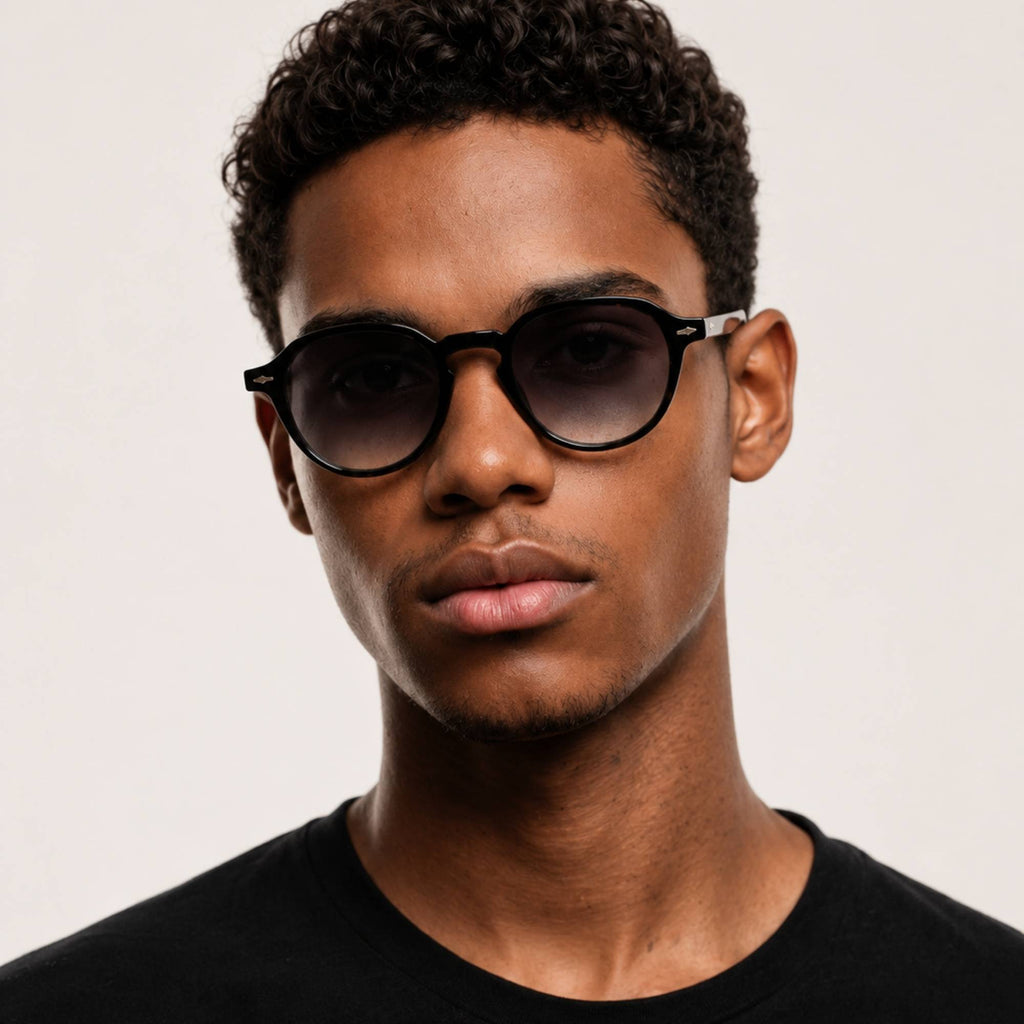 Homme portant les lunettes de soleil Lior Grey Osour Eyewear avec monture ronde noire et verres gris dégradés.