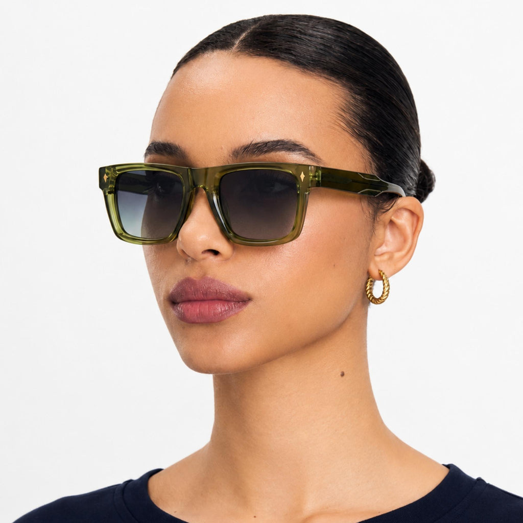 Femme portant les lunettes de soleil Olive vertes Osour Eyewear avec monture rectangulaire verte translucide et verres gris