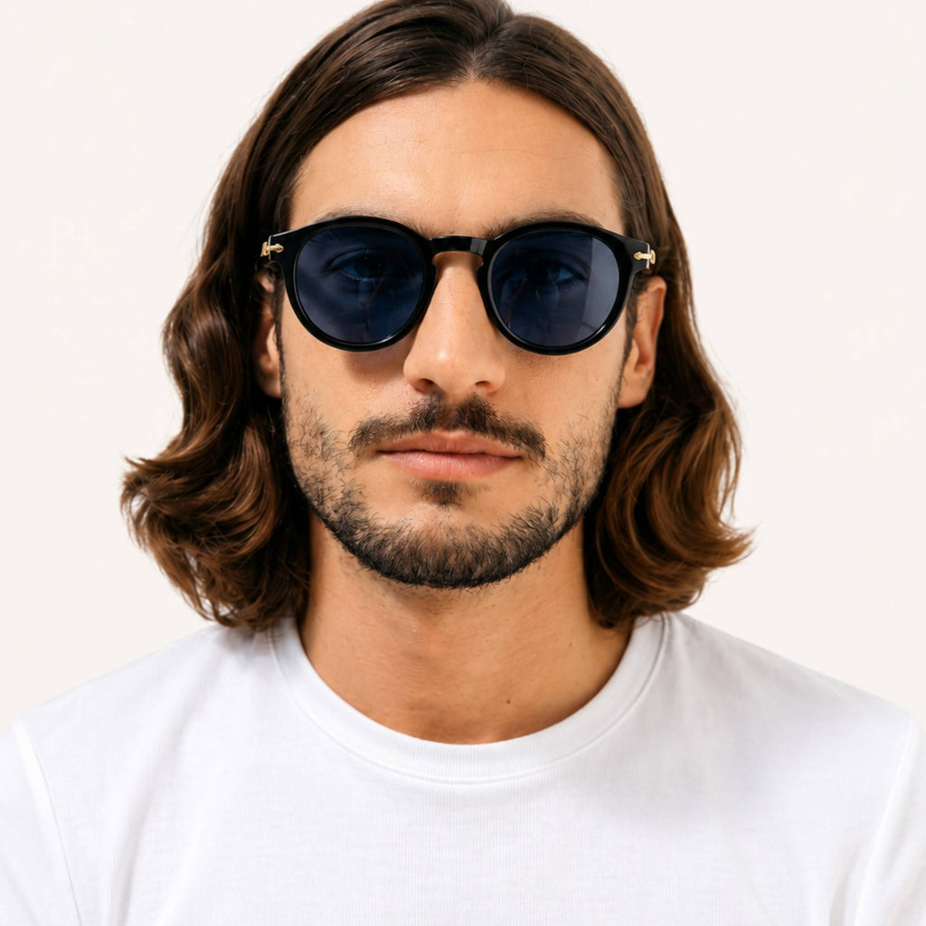 Homme portant les lunettes de soleil Smith bleues Osour Eyewear avec monture ronde et verres bleu foncé.