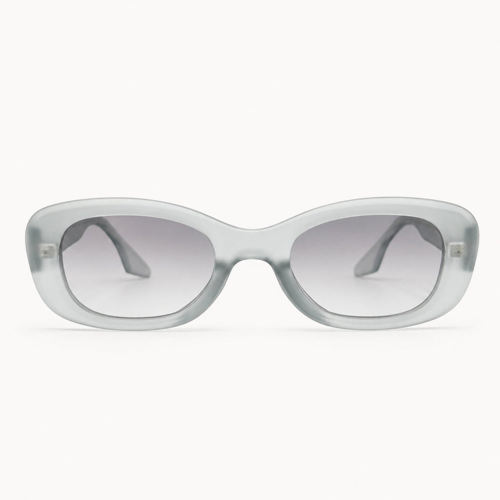 Lunettes de soleil Osour Alba Grey à monture ovale gris translucide avec verres gris dégradés, vue de face sur fond clair.